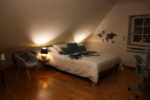 Chambre douillette sous les combles à Théière & Couverts à Cernay, décorée d'une mappemonde, éclairage chaleureux et parquet bois