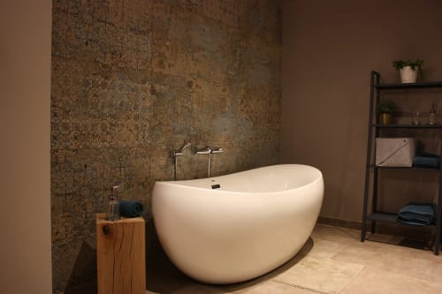Baignoire autoportante blanche et courbe avec détails en bronze dans la luxueuse salle de bains de Théière & Couverts à Cernay, France