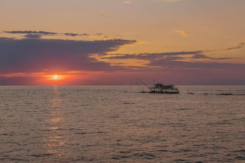 Tramonto sul Mar Tirreno con barca da pesca vicino a Tirrenia, Appartamento Tirreno