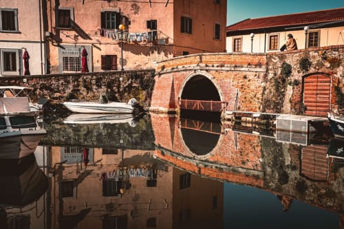 Storico ponte in laterizio si riflette nelle acque del canale a Tirrenia, Italia, vicino all'Apartment Tirreno