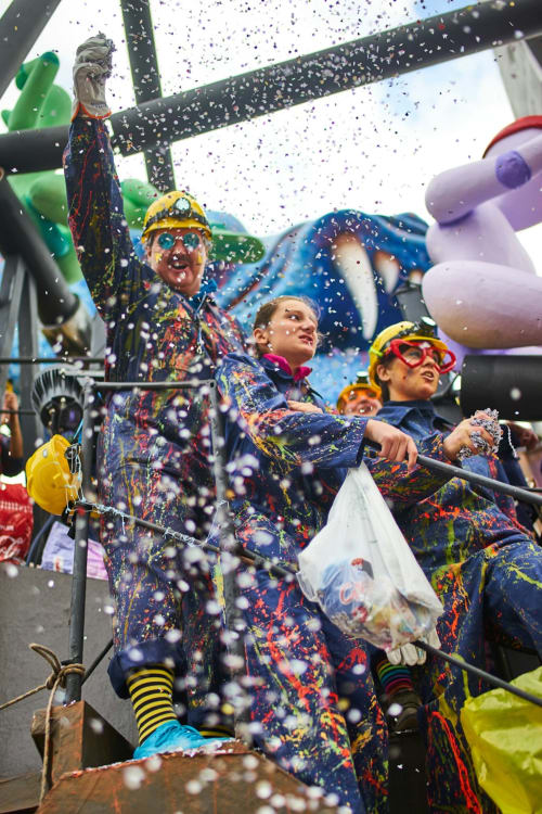 Coloratissimo carro carnevalesco con artisti in costumi festosi che lanciano coriandoli nei pressi di Tirrenia