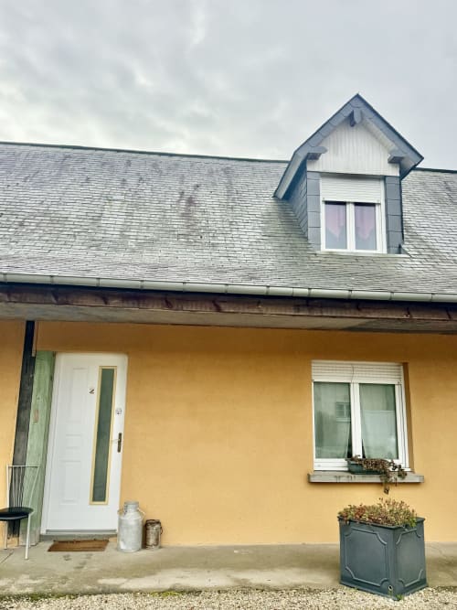 Yellow cottage exterior with white door, slate roof and dormer window at Le Clos De La Vallée, Bellengreville