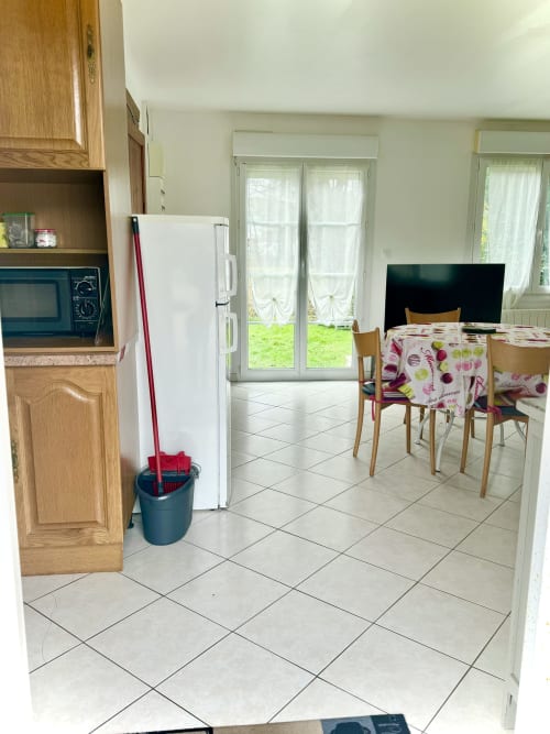 Kitchen-dining area at Le Clos de la Vallée cottage with table, chairs, appliances, and garden view doors