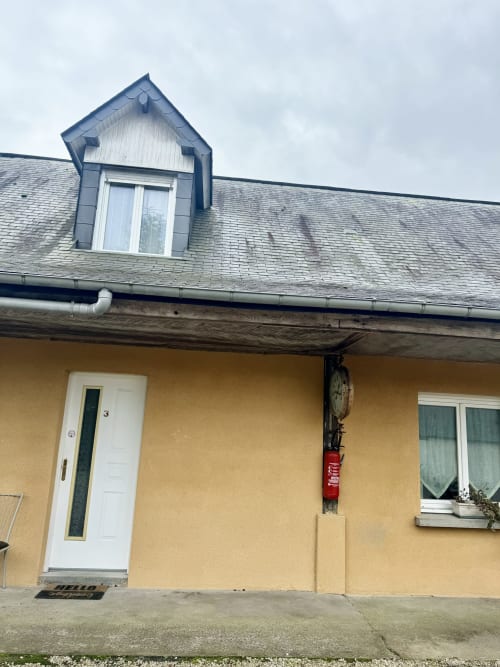 Yellow cottage Le Clos 3 at Le Clos De La Vallée in Bellengreville with white door, dormer window, and garden view