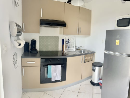 Modern kitchen in Le Clos 3 cottage at Le Clos De La Vallée with beige cabinets, black oven, stainless steel appliances and