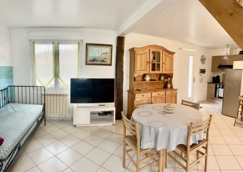 Le Clos 3 cottage dining area with round table, wooden furniture, TV, kitchen, and garden view at Le Clos De La Vallée in
