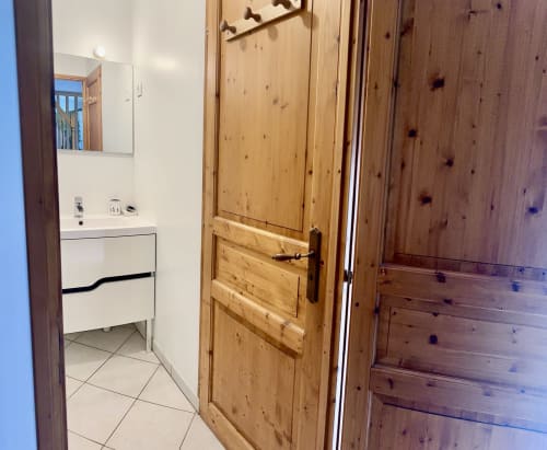 Wooden door and white bathroom vanity in Le Clos 3 cottage at Le Clos De La Vallée, Bellengreville