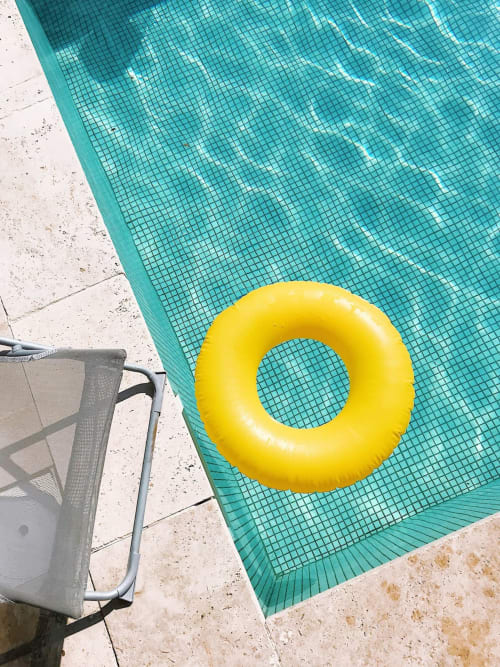 Ciambelle galleggianti gialle nella piscina turchese di Dimora i Manichei, Monforte d'Alba