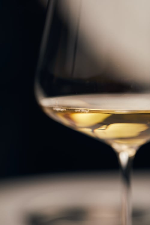 Elegante calice di vino bianco a Dimora i Manichei, esperienza di ospitalità a Monforte d'Alba