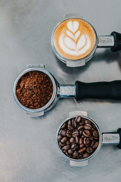 Le fasi di preparazione del caffè a Dimora i Manichei: espresso con latte art, caffè macinato e chicchi interi