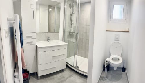 Modern bathroom at Le Clos De La Vallée cottage in Bellengreville with shower enclosure, vanity sink, and toilet