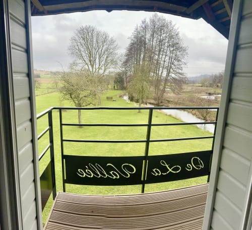 Balcony view of lush green gardens and trees at Le Clos de la Vallée cottage in Bellengreville, France
