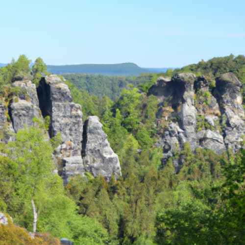 Formations de grès rocheux dans une vallée forestière avec vue sur un lac lointain, Chalet d'hôtes Les Louettes