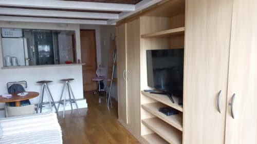 Sala moderna do Hostel New Ipanema Rio com TV tela plana, marcenaria em madeira, bar na cozinha e vista para a cidade
