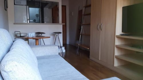 Apartamento moderno no Hostel New Ipanema no Rio de Janeiro com cama, sala, kitchenette, guarda-roupa e vista da cidade