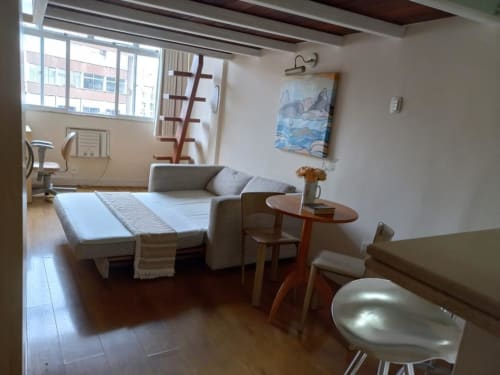 Apartamento espaçoso na Hostel New Ipanema no Rio de Janeiro com sala, sofá-cama, mesa de jantar e vista da cidade