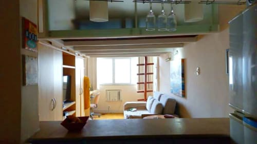 Apto aconchegante no Hostel New Ipanema, Rio de Janeiro, com sala de estar, sofá, TV, prateleiras e vista da cidade