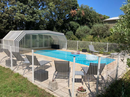Piscine du Domaine des Lavarines avec couverture rétractable, chaises longues et clôture à Morières-lès-Avignon