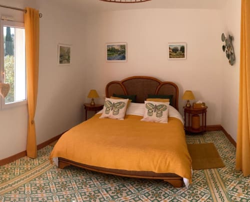 Chambre lumineuse au Domaine des Lavarines B&B à Morières-lès-Avignon avec literie orange, mobilier en bois et motifs