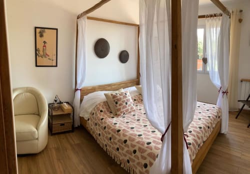 Chambre douillette du Domaine des Lavarines avec lit à baldaquin en bois et rideaux blancs à Morières-lès-Avignon