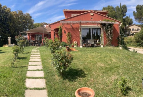 Charmant gîte en pierre rouge aux murs couverts de lierre, Domaine des Lavarines à Morières-lès-Avignon, avec jardins soignés et terrasses en pierre