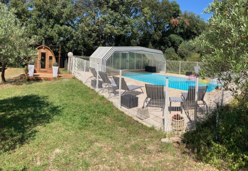 Domaine des Lavarines pool area in Morières-lès-Avignon with covered heated pool, sauna, and lush gardens