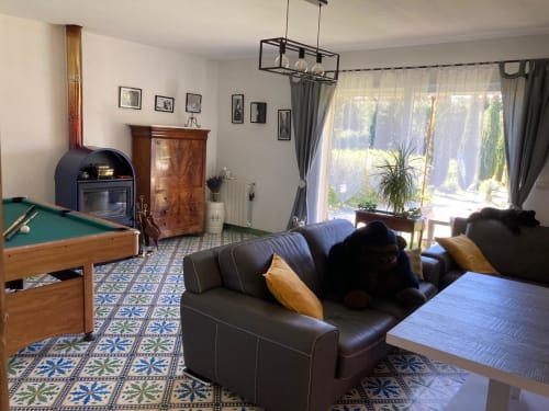 Spacieuse salle de jeux au Domaine des Lavarines avec billard, coin salon, cheminée et vue sur le jardin
