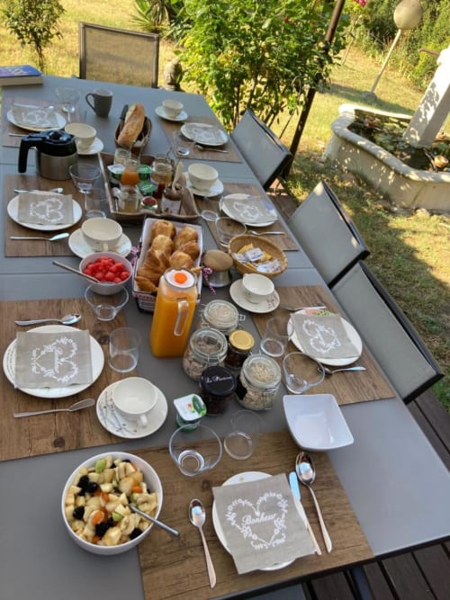 Outdoor breakfast spread at Domaine des Lavarines with pastries, fruit, juices, and place settings in Morières-lès-Avignon