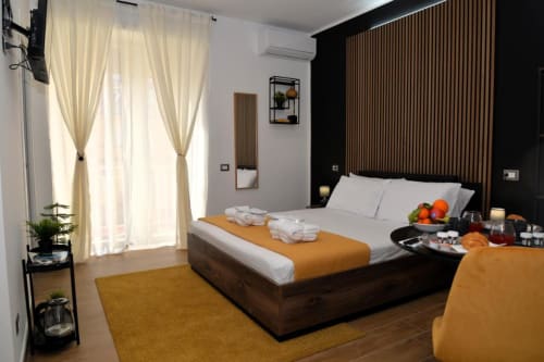 Camera moderna del Blackwoody Contemporary Hospitality BnB a Napoli con letto in legno, accenti ocra e arredamento minimalista