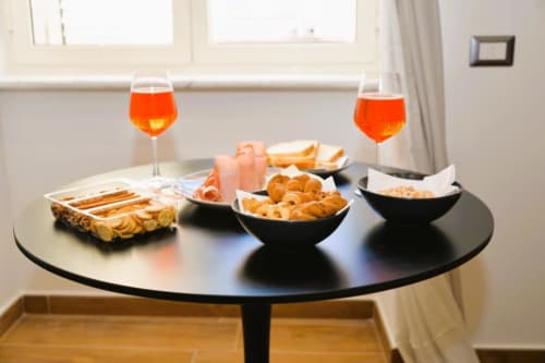 Elegante aperitivo a Blackwoody Contemporary Hospitality Napoli con pasticcini, prosciutto e cocktail Aperol Spritz