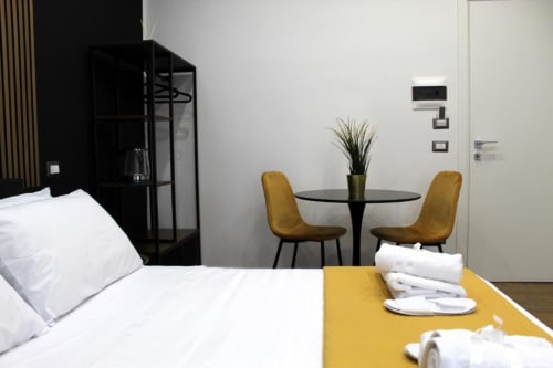 Doppia Superiore presso Blackwoody Contemporary Hospitality a Napoli con letto, tavolo da pranzo con sedie gialle e