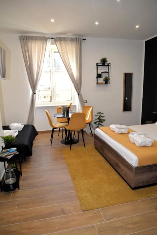 Camera moderna del Blackwoody Contemporary Hospitality a Napoli con accenti ocra, zona pranzo affacciata sulla finestra e legno