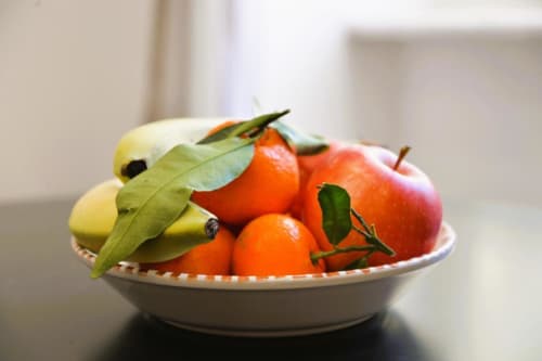 Ciotola di frutta fresca con banane, arance e mele nella sala BCH TRIBUNALI di Blackwoody Contemporary Hospitality, Napoli