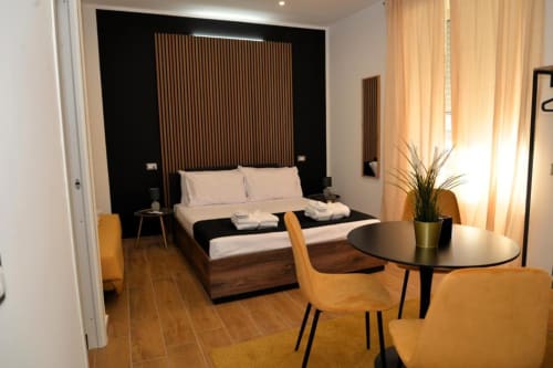 Moderna Suite Quadrupla al Blackwoody Contemporary Hospitality di Napoli con letto in legno, zona living e vista città