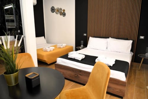 Camera contemporanea presso Blackwoody BCH Tribunali a Napoli con letto matrimoniale, accenti arancioni e design minimalista moderno