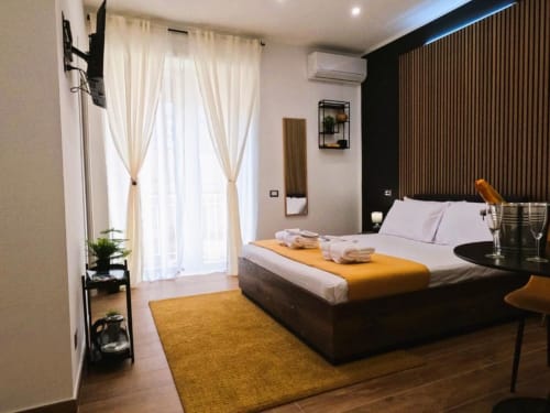 Camera Doppia Superior Moderna al Blackwoody Contemporary Hospitality di Napoli con parete nera, tappeto giallo e balcone
