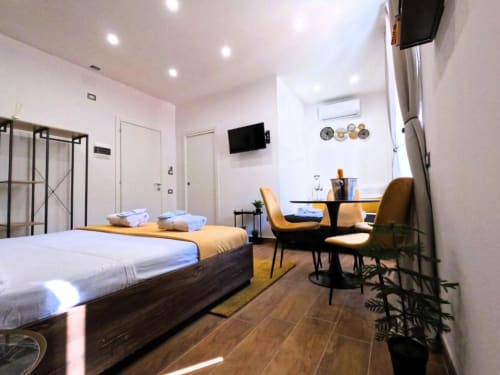 Camera moderna a Blackwoody Contemporary Hospitality, Napoli con letto matrimoniale, scrivania, zona pranzo e TV in stile contemporaneo