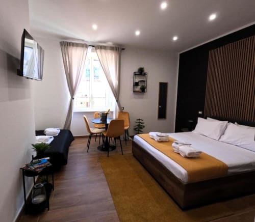 Camera moderna presso Blackwoody Contemporary Hospitality a Napoli con letto queen, zona pranzo e vista sulla città