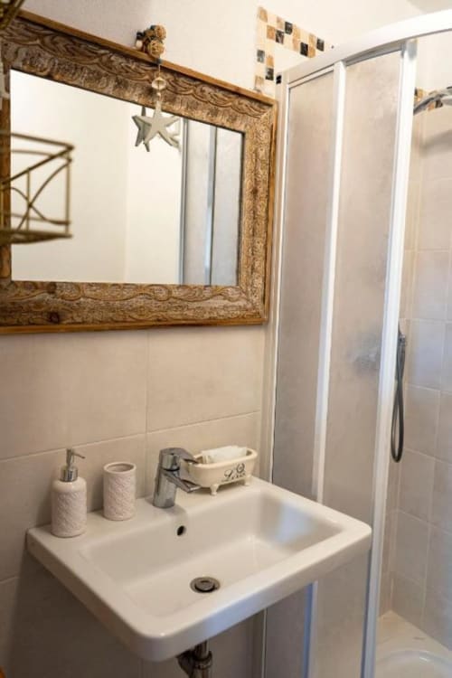 Bagno moderno con specchio dorato, lavabo bianco e doccia presso SoleMagia B&B a Vernazzo, Italia