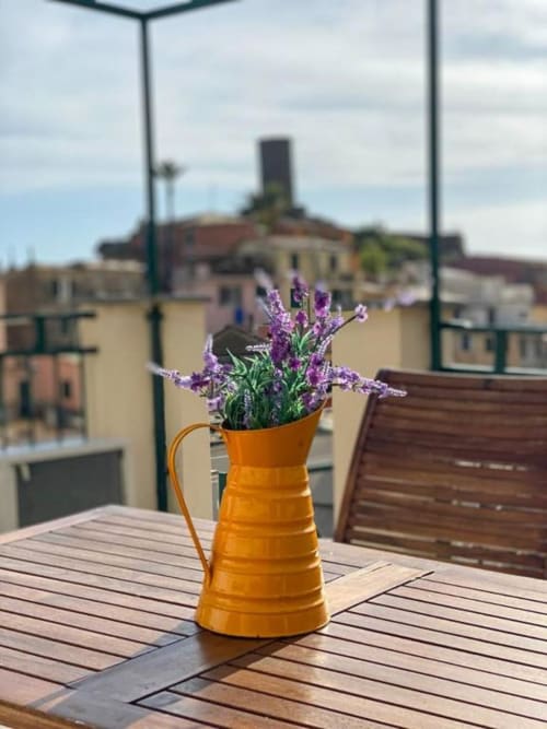Lavanda viola in brocca arancione sulla terrazza di SoleMagia, Vernazza con vista sulla città
