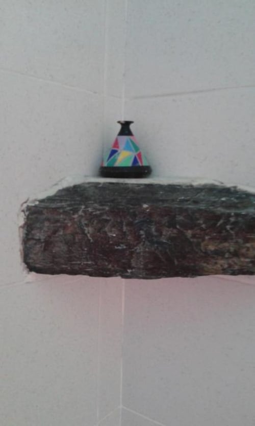 Colorato giocattolo trottola che gira su rustico scaffale di legno nel bagno di Vernazzo della SoleMagia B&B