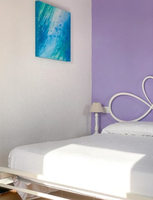Camera moderna della SoleMagia B&B a Vernazzo con arte astratta turchese, parete accent viola e biancheria bianca