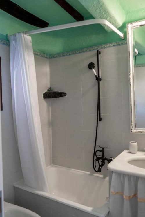 Moderno bagno con soffitto verde brillante, piastrelle bianche e rubinetteria nera nella Camera 2 SoleMagia, Vernazzo