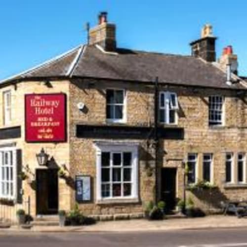 The Railway Hotel Haydon Bridge, a stone building with red signage offering bed and breakfast in Hexham