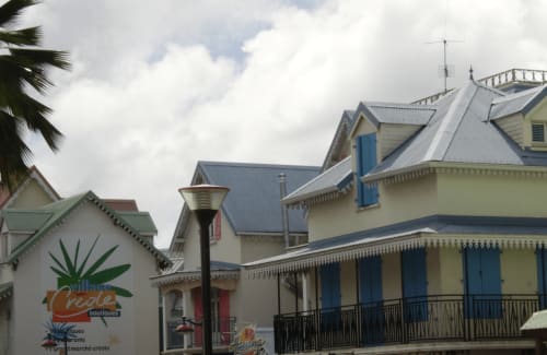 Hôtel Kay Betty aux Trois-Îlets, Martinique : bâtiments coloniaux aux façades jaunes, volets bleus et toits métalliques