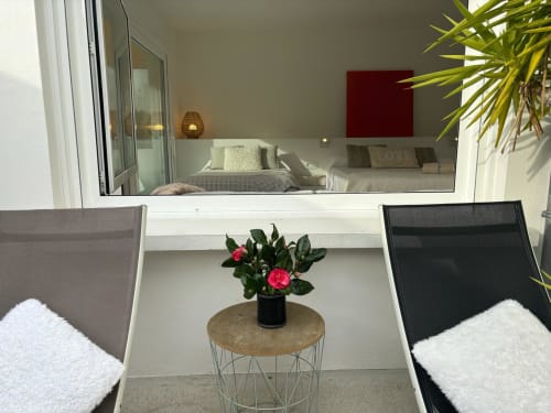 Terraza de villa moderna en Baiona con flores rosas en maceta, mobiliario confortable y vistas al mar