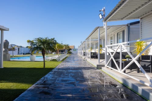 Bungalow Buda Beach Chipiona: Modern beachfront bungalows with white terraces, garden views, pool, and green lawns under