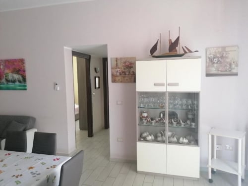 Moderna cucina e zona pranzo di La Maison Du Port a Licata, con mobili bianchi e pavimentazione in piastrelle
