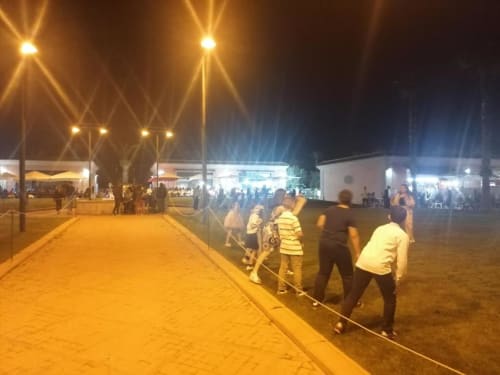 Evento notturno a La Maison Du Port a Licata con ospiti riuniti nell'area esterna illuminata del locale