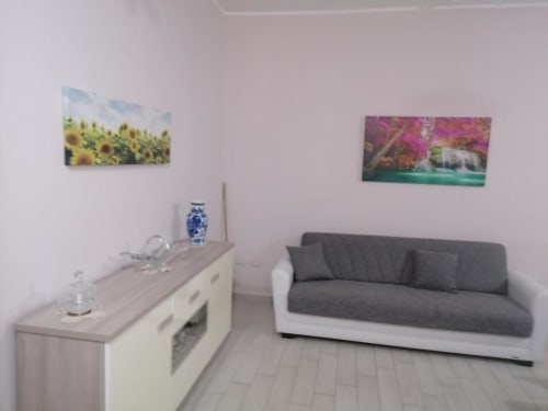 Moderna soggiorno di La Maison du Port a Licata con divano grigio, angolo cottura e arte decorativa alle pareti